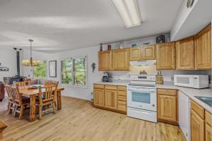 een keuken met houten kasten en een tafel en een eetkamer bij Almost Heaven - Grill, 2 King Beds, Wifi, Deck, Pool Access, Hiking, Wood Stove, Family Friendly in Berkeley Springs