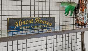 een bord op een betegelde muur met een bierfles bij Almost Heaven - Grill, 2 King Beds, Wifi, Deck, Pool Access, Hiking, Wood Stove, Family Friendly in Berkeley Springs