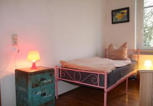 a bedroom with a bed and a lamp on a table at Pension963 in Crimmitschau