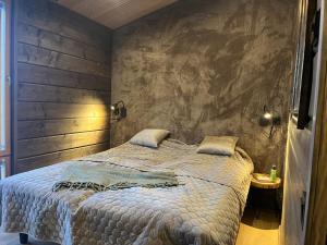 a bedroom with a large bed with a wooden wall at Villa Light in Ruka