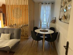a living room with a table and chairs and a couch at La Madeleine centre historique de Troyes in Troyes