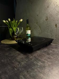 a bottle of wine sitting on a tray with wine glasses at Tyla Dviese in Bendoriai