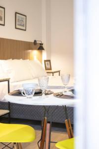 een tafel met glazen erop in een kamer met een bed bij Studio Petrópolis - Centro Histórico com Garagem in Petrópolis +39 foto's