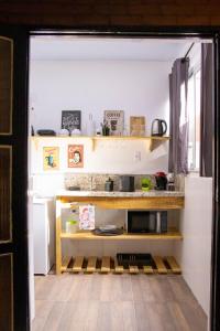 a kitchen with wooden shelves and a microwave at Centro Histórico com Garagem - Studio Petrópolis in Petrópolis