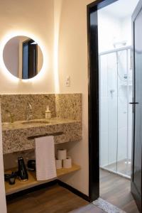 een badkamer met een wastafel en een spiegel bij Studio Petrópolis - Centro Histórico com Garagem in Petrópolis