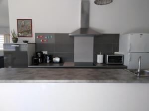 a kitchen with a stove and a refrigerator at Le Golfe in Figari