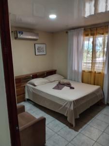 une chambre avec un lit et une chaise dans l'établissement HOSTEL CASA MARINA, à Puerto Limón