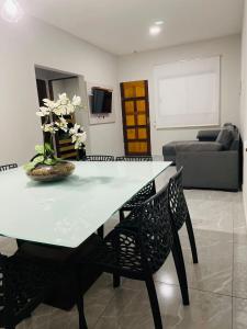 een eettafel en stoelen in de woonkamer bij Bertioga Rio da Praia in Bertioga