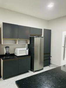 een keuken met een koelkast en een magnetron op een aanrecht bij Bertioga Rio da Praia in Bertioga