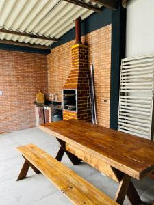 a wooden table in a kitchen with a brick oven at Bertioga Rio da Praia in Bertioga