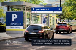 two cars parked at a parking booth on a street at SERENITY Aparthotels - Old Town Poznan by Friendly Apartments in Poznań +90 photos
