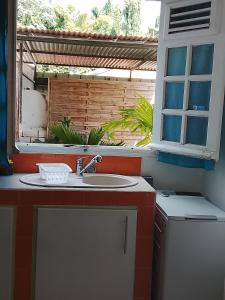 ein Badezimmer mit Waschbecken und Fenster in der Unterkunft SWEET PARADISE STUDIO à 10 mn du centre en voiture in Fort-de-France