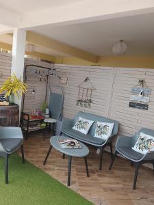 eine Terrasse mit zwei blauen Stühlen und zwei Tischen in der Unterkunft SWEET PARADISE STUDIO à 10 mn du centre en voiture in Fort-de-France