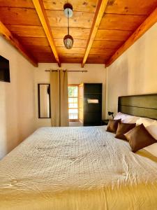 een slaapkamer met een groot bed met een houten plafond bij Zoola Suites Antigua in Antigua Guatemala