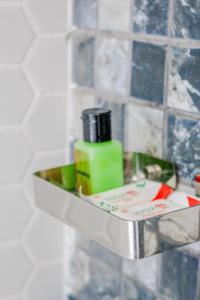 a metal shelf in a bathroom with soap and cosmetics at The Birdy Retreat Ella in Ella