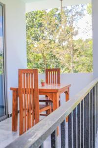 a wooden table and two chairs on a porch at The Birdy Retreat Ella in Ella
