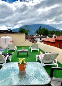 a patio with a table and chairs on a roof at Zoola Suites Antigua in Antigua Guatemala