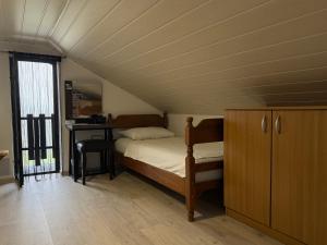 een slaapkamer met een bed en een bureau op zolder bij Kuća za odmor Hrešć in Donji Koncovčak