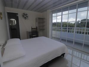 een slaapkamer met een wit bed en een groot raam bij Hotel Alcalá in Alcalá