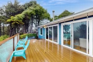 a deck with two blue chairs on a house at Saltwind Shores in Moclips