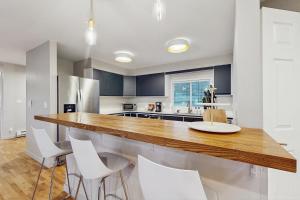 a kitchen with a wooden counter and white chairs at Saltwind Shores in Moclips