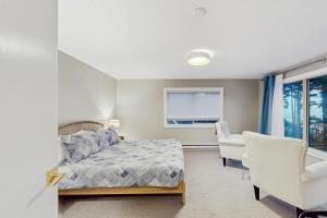 a bedroom with a bed and a chair and a window at Saltwind Shores in Moclips