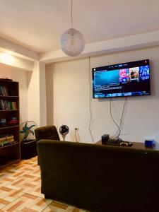 een woonkamer met een bank en een flatscreen-tv bij Zoola Suites Antigua in Antigua Guatemala +29 foto's