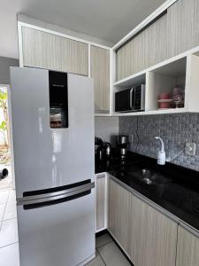 a kitchen with a white refrigerator and a sink at Casa em Imbituba SC, perto das Praias e Lagoa in Imbituba +10 photos