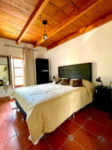 een slaapkamer met een groot bed met een houten plafond bij Zoola Suites Antigua in Antigua Guatemala