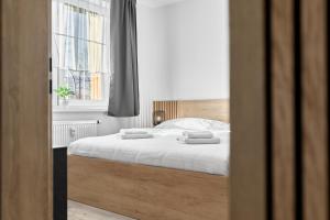 a bedroom with a bed with two towels on it at Rezidence George by Mountain ways in Kovářská