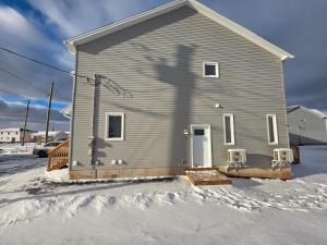 De schaduw van een persoon op een huis in de sneeuw. bij Quiet Comfort Suite in Moncton