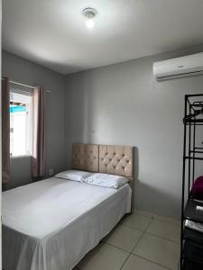 a bedroom with a bed and a window at Casa em Imbituba SC, perto das Praias e Lagoa in Imbituba