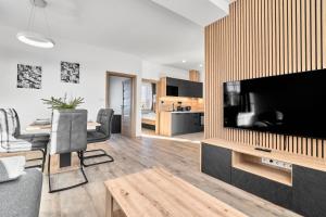 a living room with a large flat screen tv at Rezidence George by Mountain ways in Kovářská