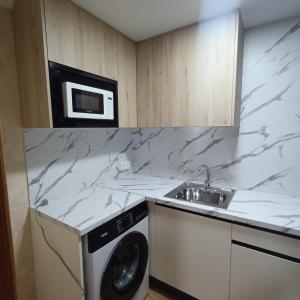 a kitchen with a washing machine and a microwave at Hostal Los Palancares in Fuentes +6 photos