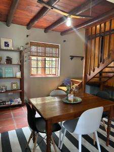 een eetkamer met een houten tafel en stoelen bij The Little Thatch Cottage in Greyton +12 foto's