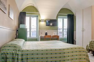 a bedroom with a bed and a table with chairs at Hotel POSTA - Comfortable Stay in Ventimiglia in Ventimiglia