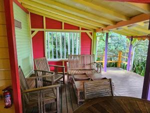 un porche d'une maison avec des chaises et une table dans l'établissement Gites Cabazat, à Bouillante
