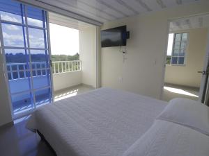 een slaapkamer met een bed en een groot raam bij Hotel Alcalá in Alcalá