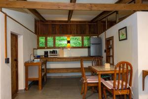 eine Küche und ein Esszimmer mit Tisch und Stühlen in der Unterkunft Bhoga Forest 