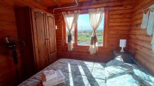 - une chambre avec un lit et une fenêtre dans une cabane en rondins dans l'établissement Cabañas Angualasto, à Uspallata 85 autres photos