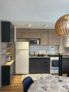 een keuken met een witte koelkast en een tafel bij Balcarce Apartment in Vuelta del Paraguayo