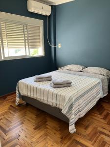 een slaapkamer met een bed met twee handdoeken erop bij Balcarce Apartment in Vuelta del Paraguayo