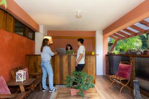 Eine Gruppe von Menschen steht an einer Bar in einem Haus in der Unterkunft Bhoga Forest 