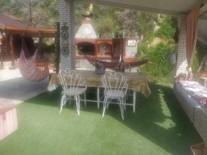 een patio met 2 stoelen en een tafel met een open haard bij Ramon del Xalet in Ibars de Noguera