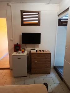a living room with a television and a dresser at Le Refuge de Nicolas in Quartier Morne Acajou