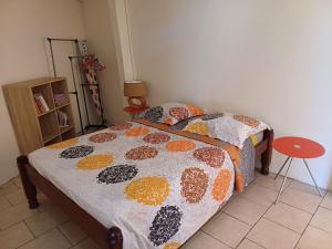a bedroom with a bed with a comforter on it at Le Refuge de Nicolas in Quartier Morne Acajou +17 photos