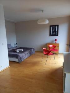 a bedroom with a bed and two red chairs at Studio Deluxe in Tallinn