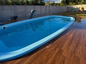a large blue swimming pool with a wood floor at Recanto Carvalhos in Tiradentes