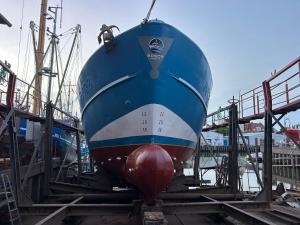 a blue and white boat sitting on the tracks at MV Marlies in Ons Belang