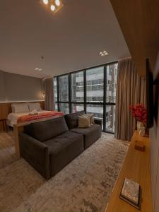 a living room with a couch and a bed at Infinity Tower Flat 1105 in Itapema